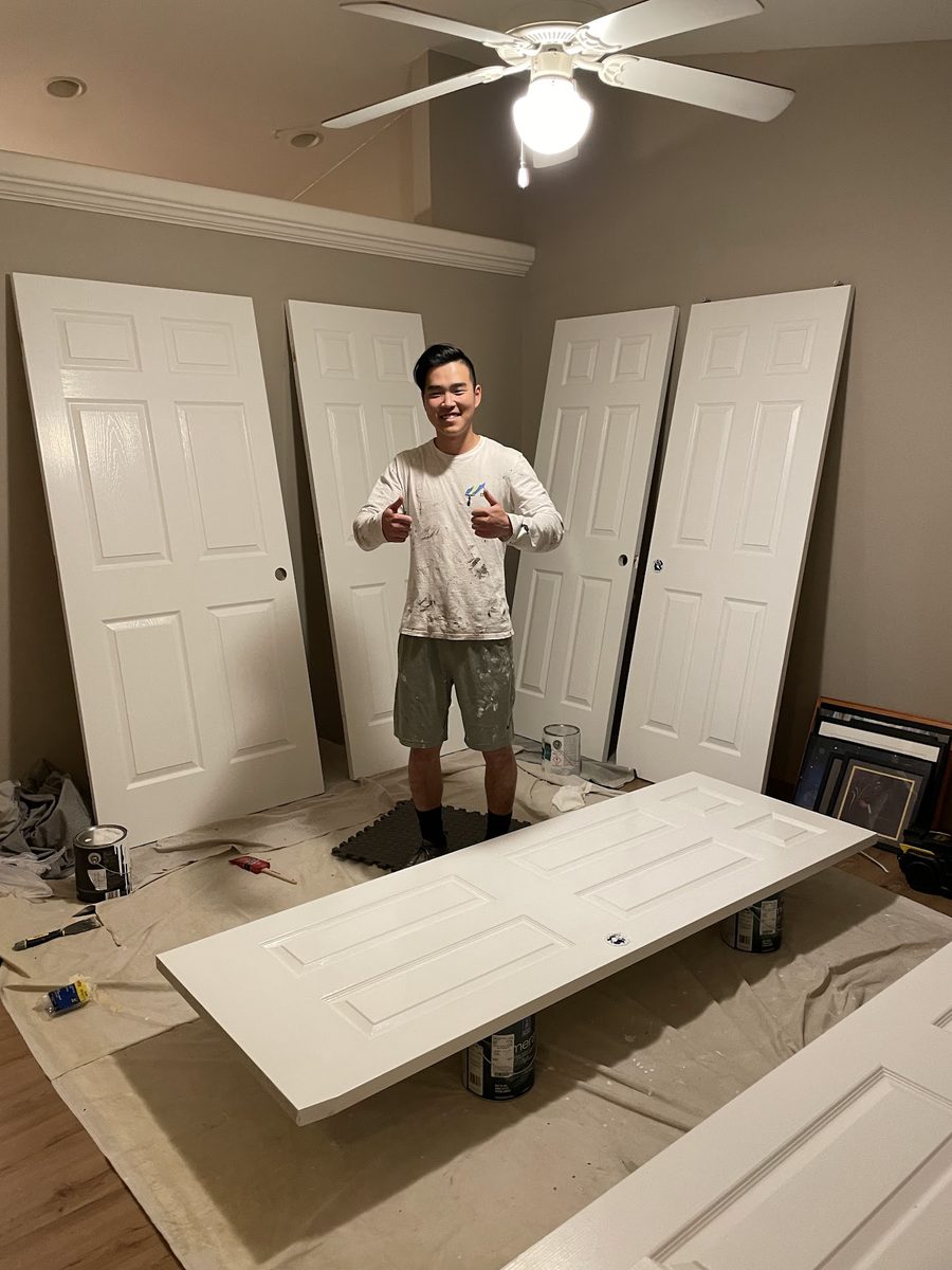 Crew member with a room of freshly sprayed interior doors